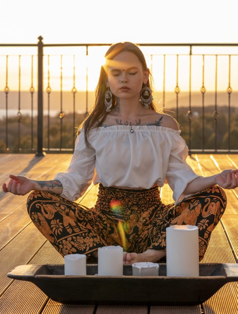Woman meditating at sunset outdoors.